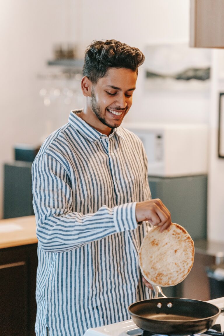 Happy man cooking a roti.